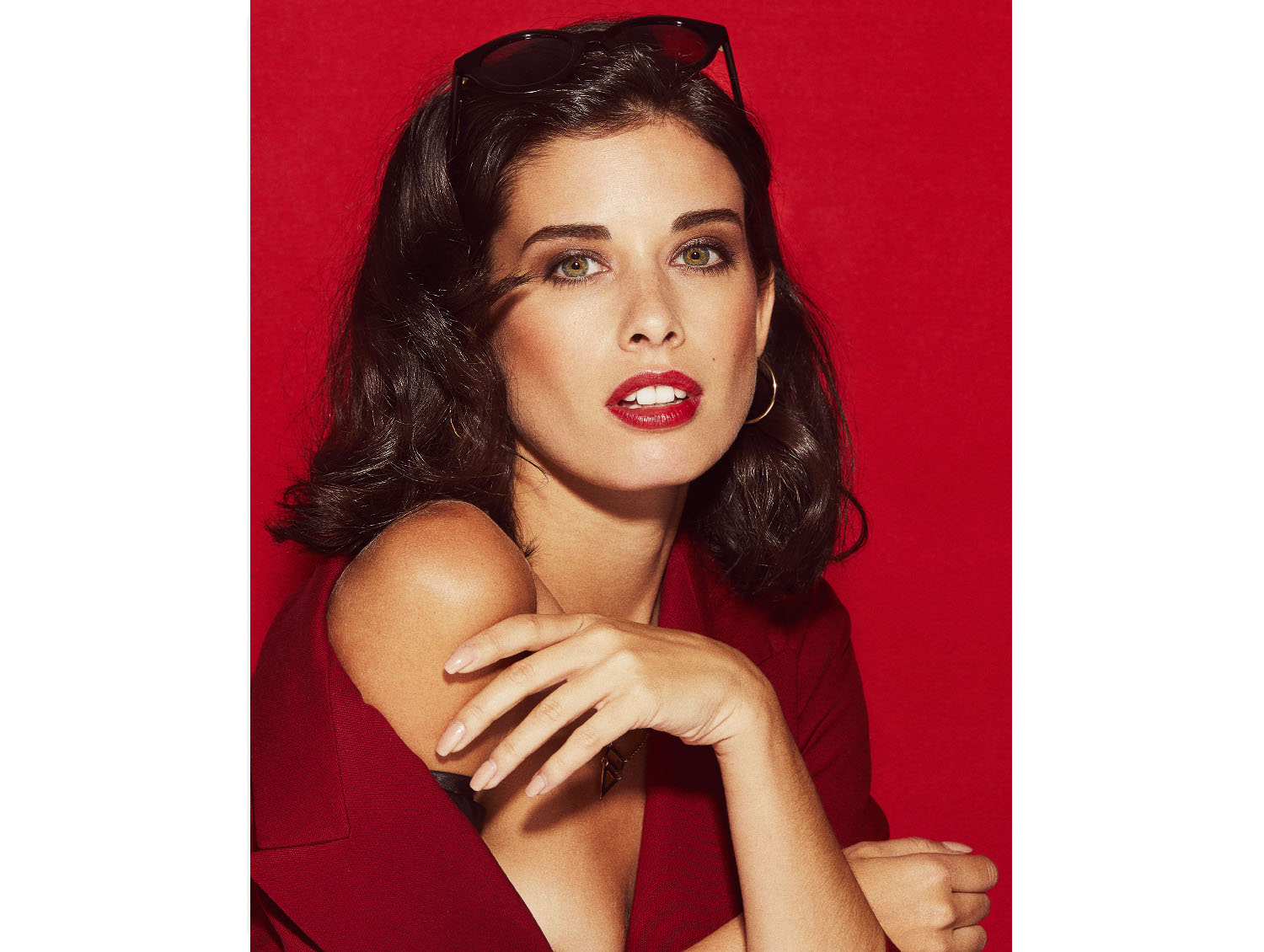 Retrato beauty estilo 80s con eyeliner gráfico en fondo rojo